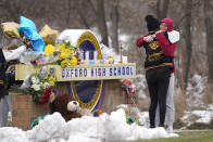 Students hug at a memorial at Oxford High School in Oxford, Mich., Wednesday, Dec. 1, 2021. Authorities say a 15-year-old sophomore opened fire at Oxford High School, killing four students and wounding seven other people on Tuesday. (AP Photo/Paul Sancya)