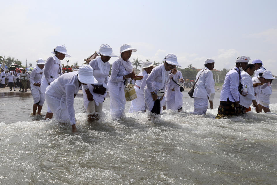 Balinese Hindus participate in a purification ceremony on Melasti at Petitenget beach in Bali, Indonesia on Friday, March 8, 2024. Melasti is part of the six-day long Balinese Hindu New Year, where devout perform rituals as an act of symbolic cleansing. (AP Photo/Firdia Lisnawati)