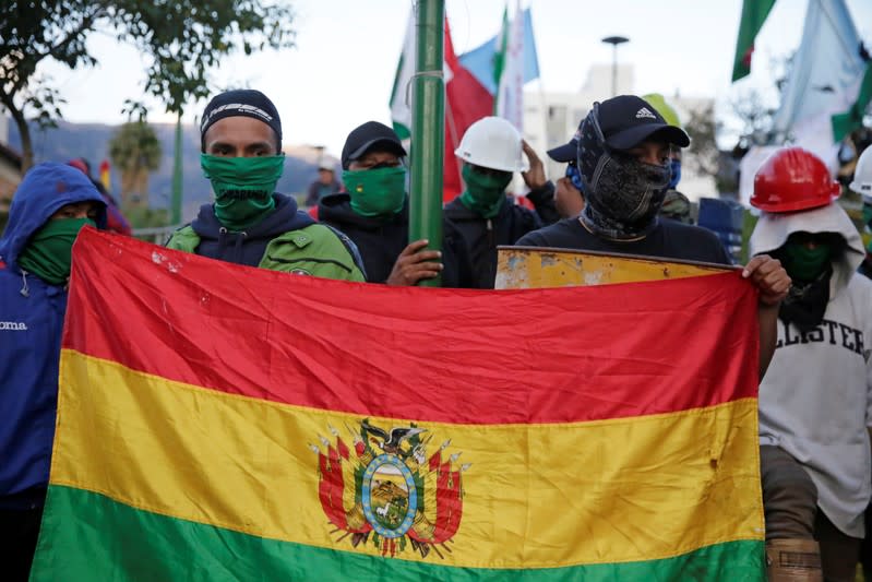 Members of Youth Resistance "Cochala" group hold a national flag at Cala Cala square in Cochabamba