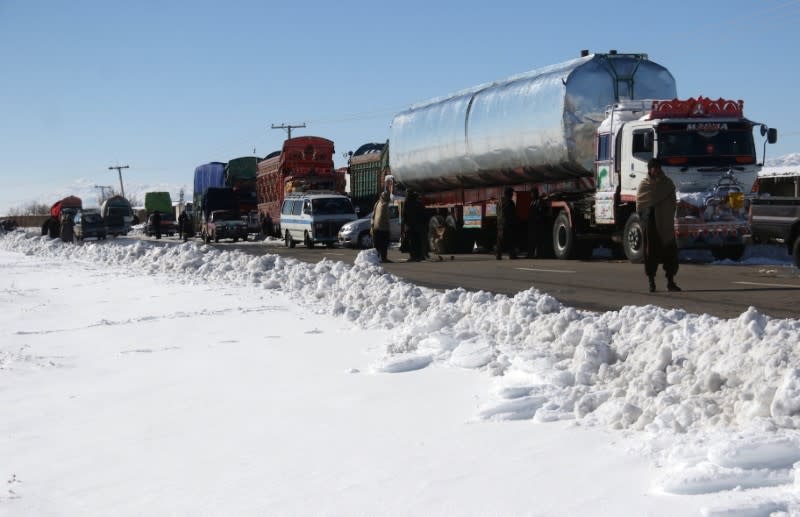 Vehicles are seen parked along the road, leading to the area with a heavy snowfall, on the outskirts of Quetta,