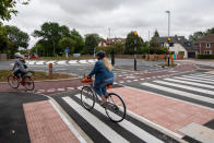 Cyclist use the UK's first Dutch-style roundabout � which prioritises cyclists and pedestrians over motorists � after it opened in Fendon Road, Cambridge. The cost of the scheme, originally estimated at around GBP 800,000, has almost trebled to GBP 2.3m at the end of the project.