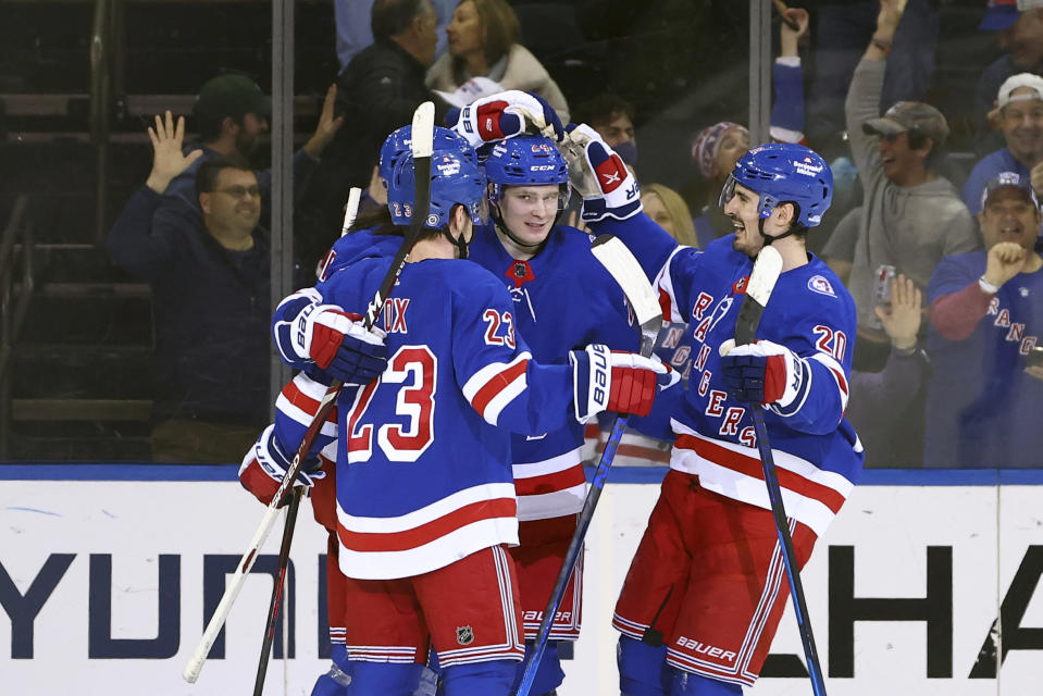 New York Rangers center Mika Zibanejad (93) is congratulated by defenseman Adam Fox (23), right wing Kaapo Kakko (24) and left wing Chris Kreider (20) after scoring a goal against the Tampa Bay Lightning during the first period of an NHL hockey game, Sunday, Jan 2, 2022, at Madison Square Garden in New York. (AP Photo/Rich Schultz)
