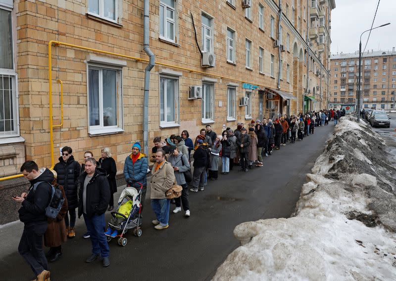 Varias personas hacen cola para entrar en un colegio electoral hacia el mediodía del último día de las elecciones presidenciales en Moscú, Rusia