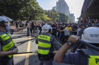 Police clash with demonstrators during a protest against fascism, President Jair Bolsonaro and to defend democracy in Sao Paulo, Brazil, Sunday, May 31, 2020. Police used tear gas to disperse anti-government protesters in Brazil's largest city as they began to clash with small groups of demonstrators loyal to President Jair Bolsonaro. (AP Photo/Andre Penner)