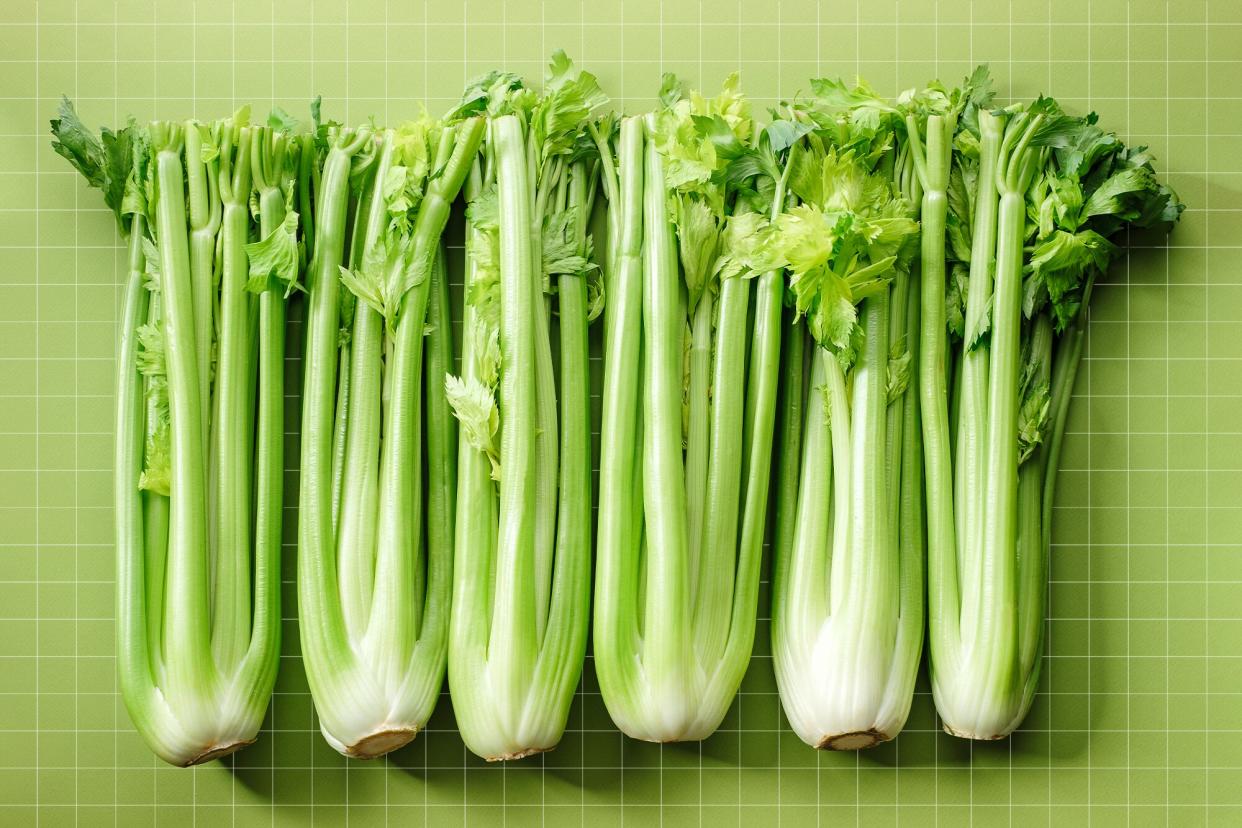 6 bundles of celery on a green background with a grid