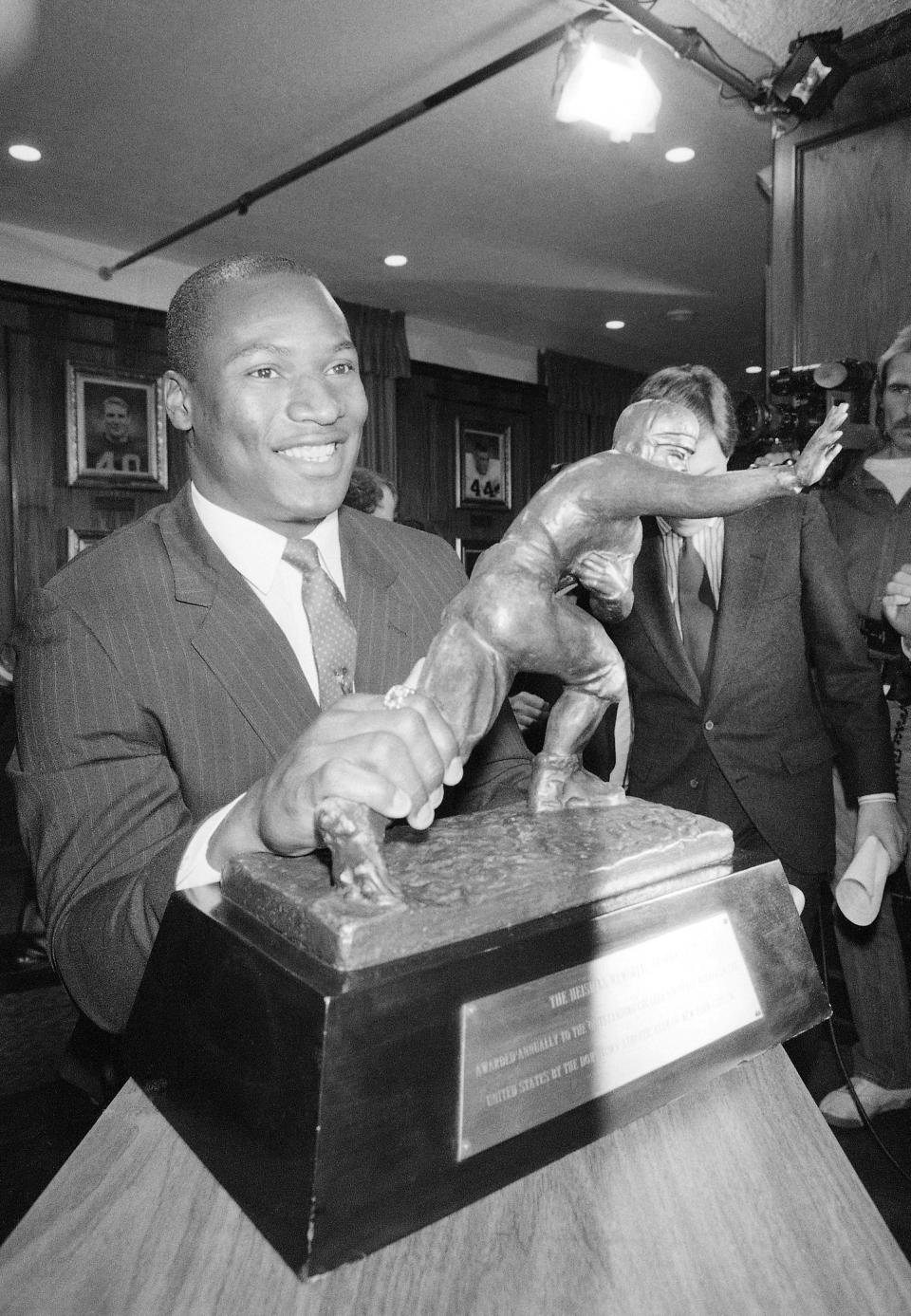 FILE - In this Dec. 9, 1985, file phot, Heisman Trophy winner Bo Jackson, the tailback at Auburn, poses with the trophy after being named the top college football player in New York. Florida State's Jameis Winston will become the sixth Heisman winner to play college baseball after winning the award and the first since Bo Jackson in 1986. Winston is the Seminoles' closer, will DH and play outfield. (AP Photo/G. Paul Burnett, File)