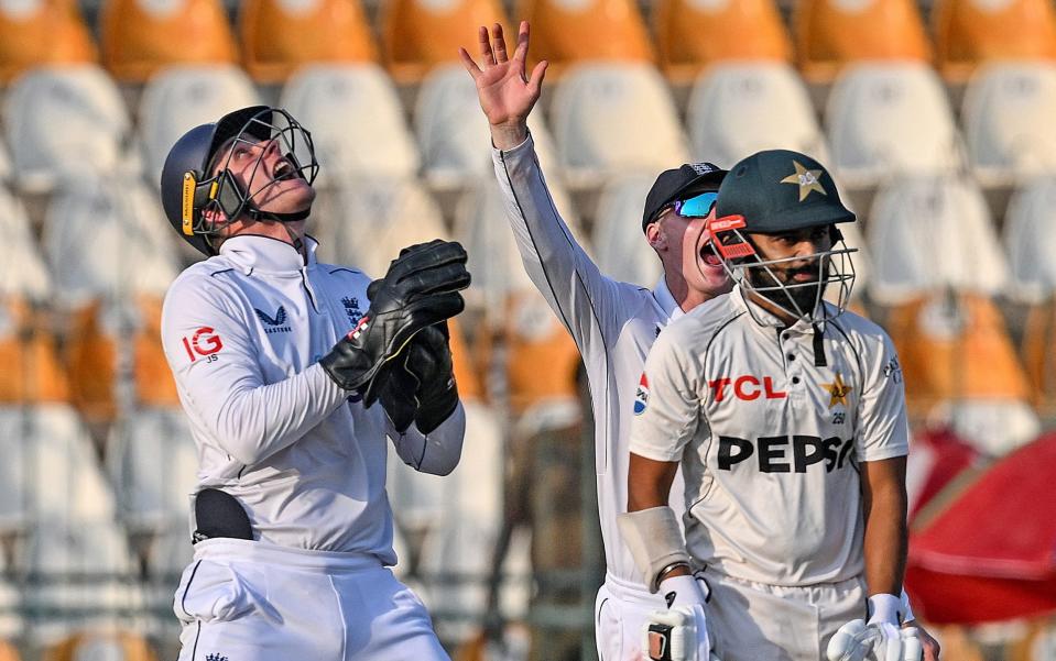 England's wicketkeeper Jamie Smith (L) takes a catch to dismiss Pakistan's Saud Shakeel (R) during the fourth day of the first Test cricket match between Pakistan and England at the Multan Cricket Stadium in Multan on October 10, 2024