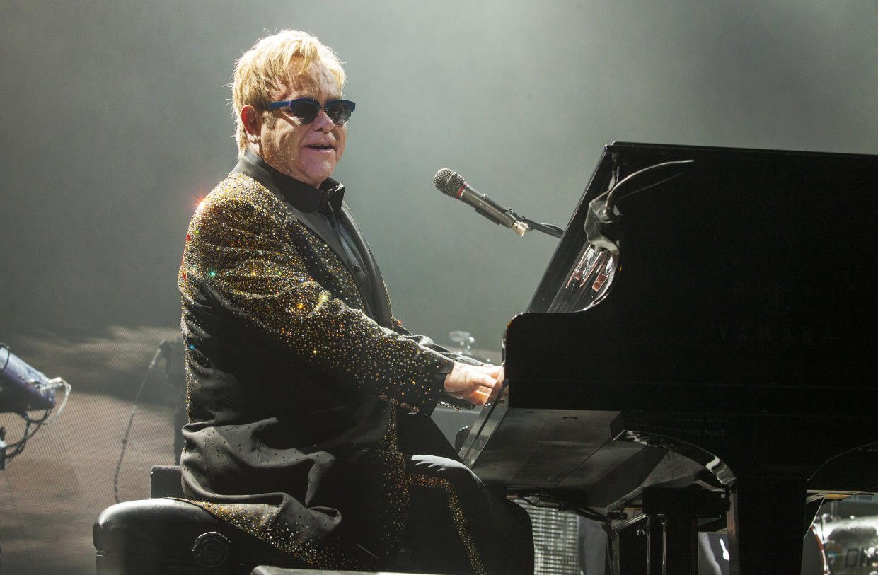 Sir Elton John performs at the piano.