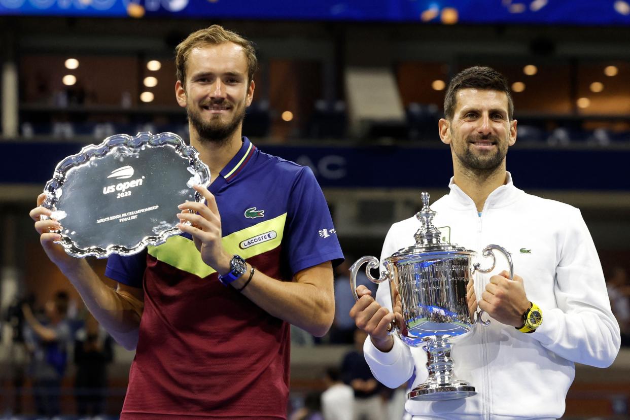 Novak Djokovic poses with the trophy after defeating Russia's Daniil Medvedev, left (AFP via Getty Images)