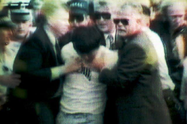 <p>THOMAS CHENG/AFP via Getty Images</p> An image taken from a television broadcast of the arrest after Prince Charles was shot at on Australia Day, Jan. 26, 1994.
