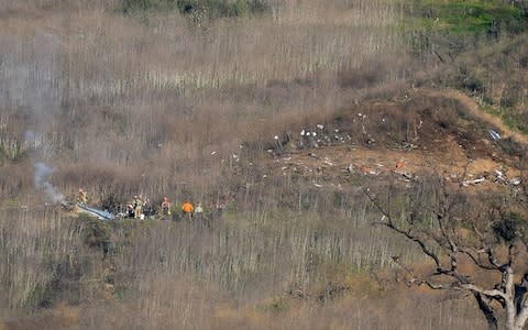 Members of LA County Fire and LA County corners begin the task of removing bodies from the hillside  - Credit: USA Today