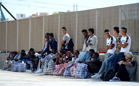 Migrants wait to embark a ferry to the mainland, in Lampedusa