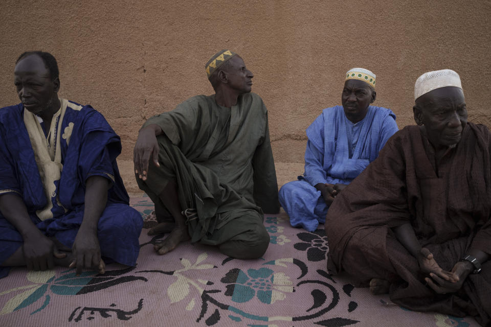 Oumar Koume, left, sits with other relatives during an interview in Selibaby, Mauritania, Tuesday, Dec. 7, 2021. Koume's son, Djibi Koume, was among 43 people to have boarded the boat that was found in Tobago on May 28, 2021, more than four months after its departure from Mauritania in an attempt to reach Spain's Canary Islands. (AP Photo/Felipe Dana)