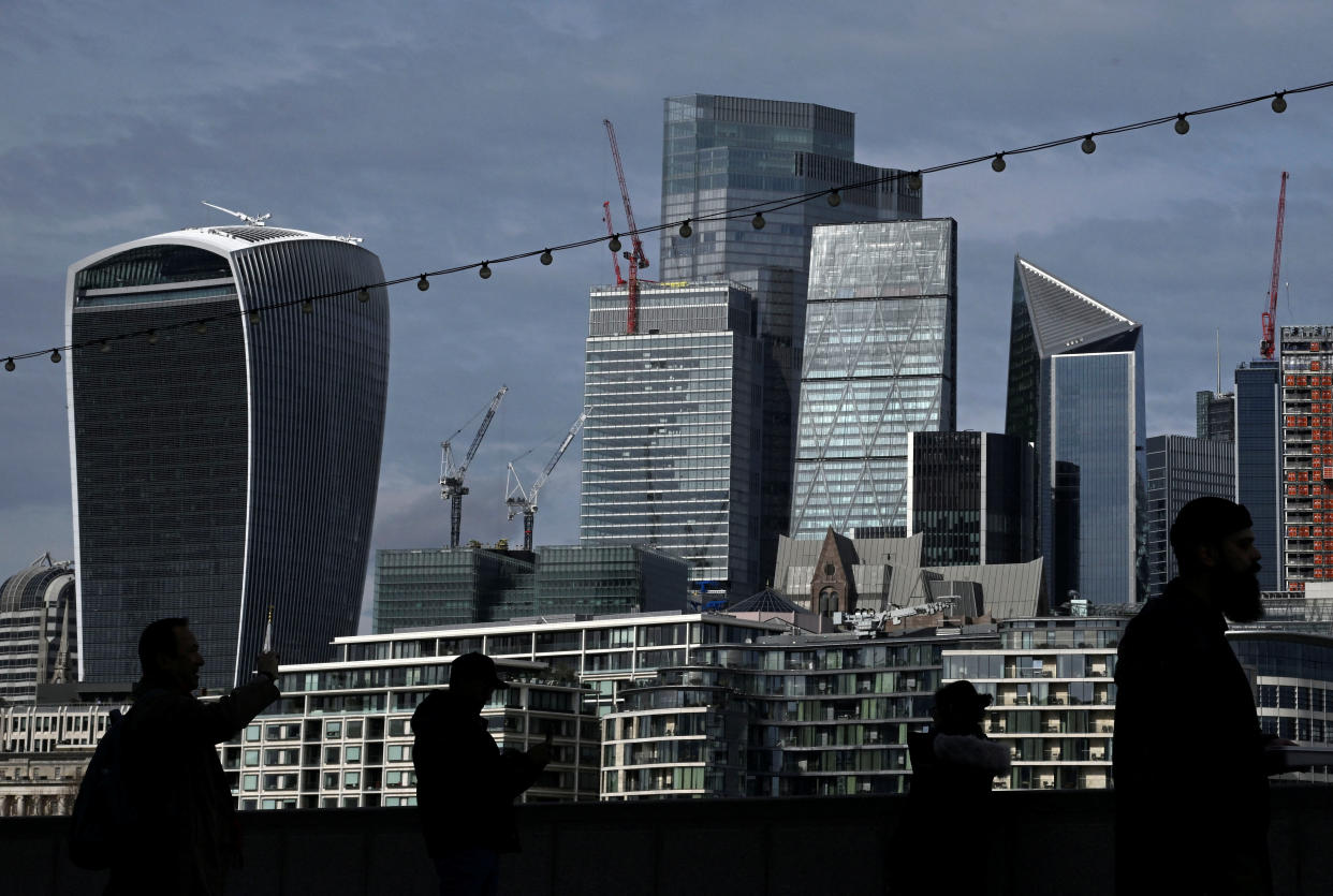 FTSE  People walk with skyscrapers in the City of London financial district seen behind in London, Britain, March 16, 2023. REUTERS/Toby Melville