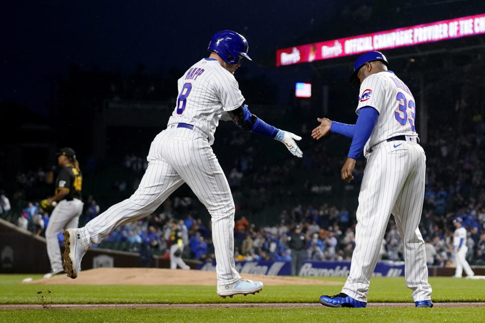 Chicago Cubs' Ian Happ runs the bases and is congratulated by third base coach Willie Harris after his three-run home run off Pittsburgh Pirates starting pitcher Luis Ortiz during the first inning of a baseball game Tuesday, June 13, 2023, in Chicago. (AP Photo/Charles Rex Arbogast)