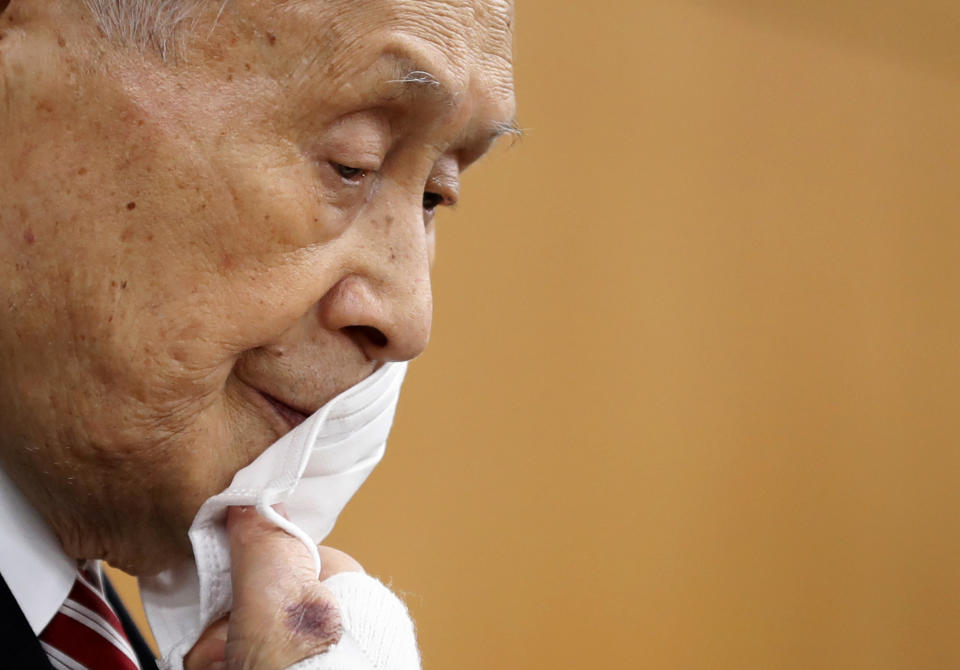 FILE - In this Feb. 4, 2021, file photo, Yoshiro Mori, the president of the Tokyo Olympic Organizing Committee, takes off his protective face mask as he attends a news conference in Tokyo. Mori — a former prime minister — stepped down after making derogatory comments about women. (Kim Kyung-hoon/Pool Photo via AP, File)