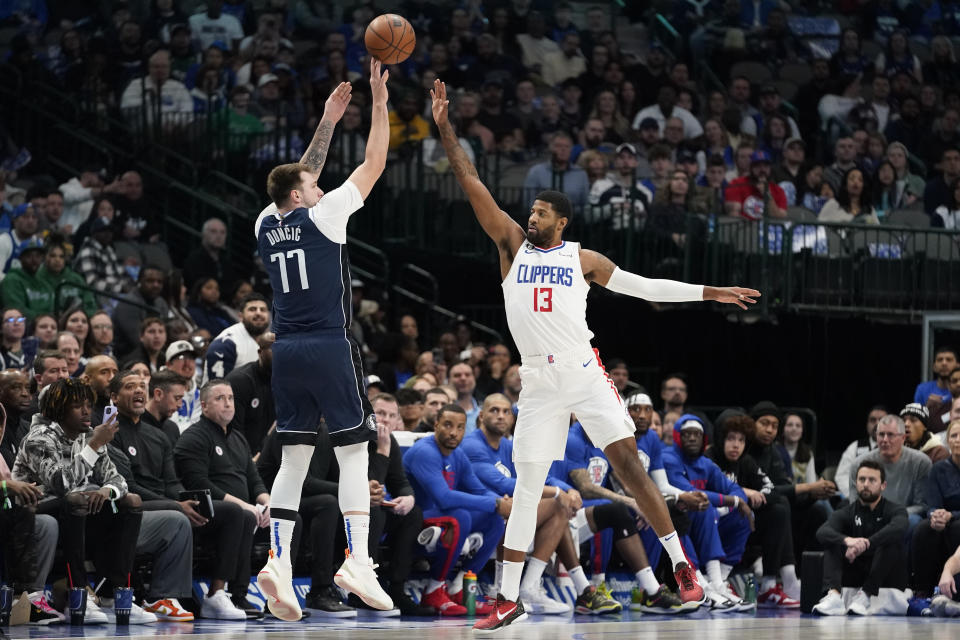 Dallas Mavericks guard Luka Doncic (77) shoots against Los Angeles Clippers guard Paul George (13) during the first quarter of an NBA basketball game in Dallas, Sunday, Jan. 22, 2023. (AP Photo/LM Otero)