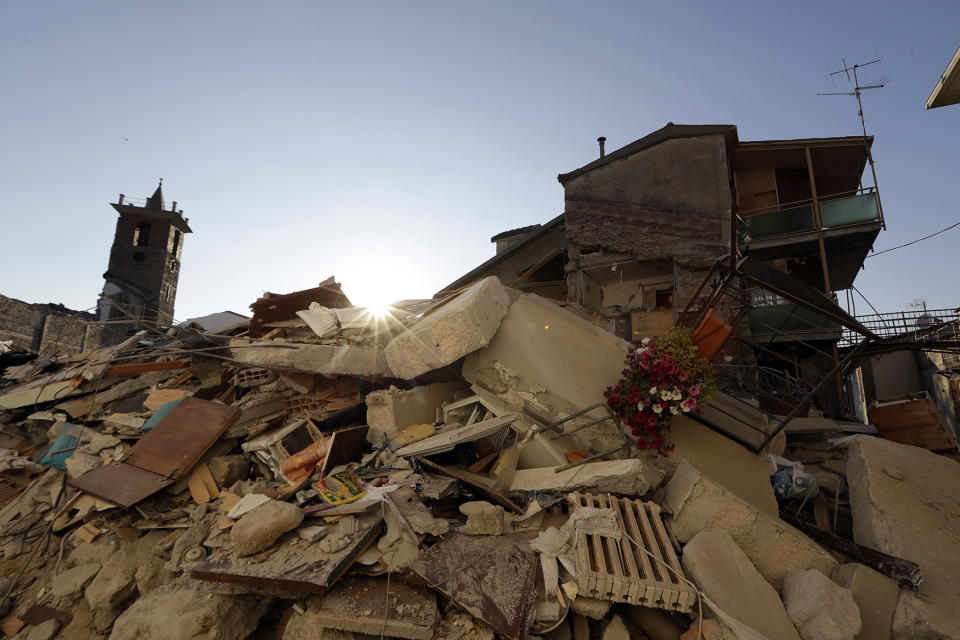 <p>The sun sets behind collapsed houses in the village of Santi Lorenzo e Flaviano, central Italy, Aug. 27, 2016. (AP Photo/Andrew Medichini) </p>