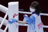 FILE - In this July 30, 2021, file photo, cleaning crew worker wipes down the ring before the men's heavyweight 91-kg boxing match at the 2020 Summer Olympics, in Tokyo, Japan. Tokyo Olympians are exercising extraordinary discipline against the coronavirus. They are sealed off in a sanitary bubble that has made competition possible but is also squeezing a lot of fun from their Olympic experience. (AP Photo/Frank Franklin II, File)