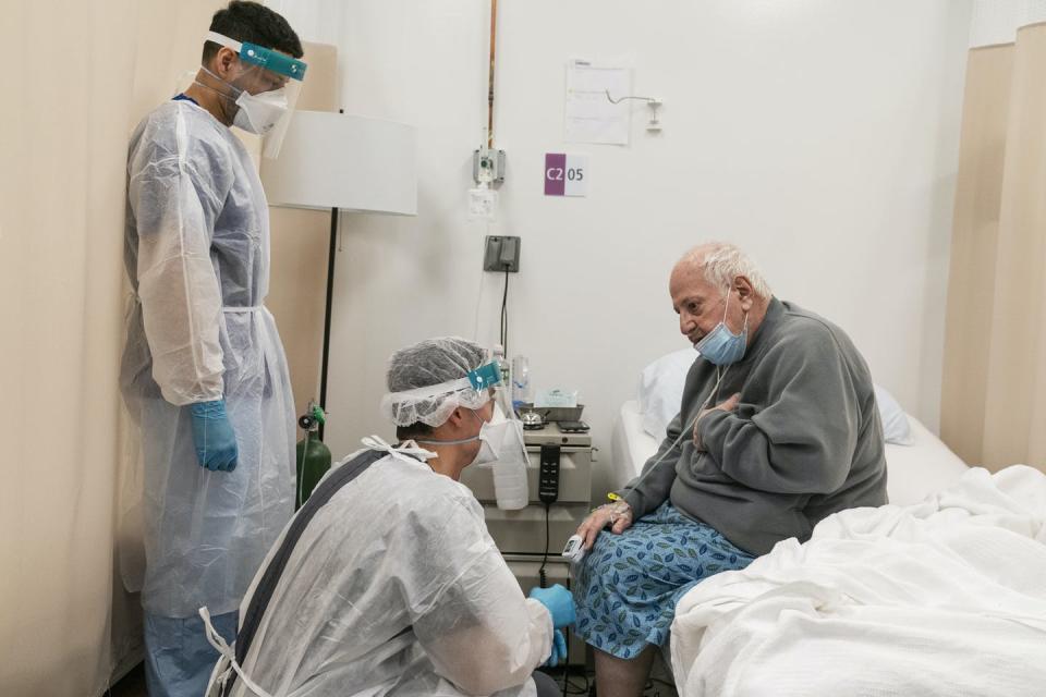 A physical therapist talks with a COVID-19 patient in Cranston, Rhode Island.