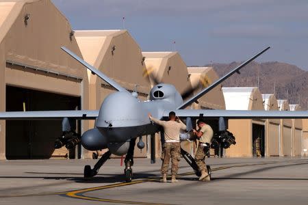 U.S. airmen prepare a U.S. Air Force MQ-9 Reaper drone as it leaves on a mission at Kandahar Air Field, Afghanistan March 9, 2016. REUTERS/Josh Smith