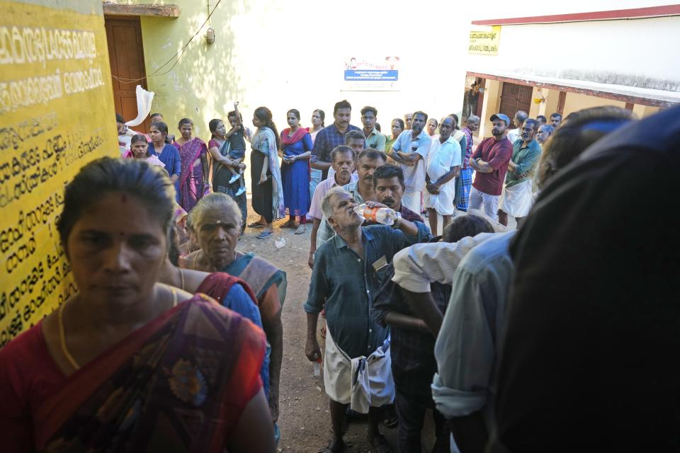 A person drinks water to beat thirst and humidity as he queues up to vote during second phase of national election, near Palakkad, in southern state of Kerala, India, Friday, April 26, 2024. (AP Photo/Manish Swarup)