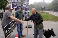 New Hampshire Republican U.S. Senate candidate Don Bolduc shakes hands with campaign volunteers while arriving with his dog "Victor" before voting, Tuesday, Sept. 13, 2022, in Stratham, N.H. (AP Photo/Charles Krupa)