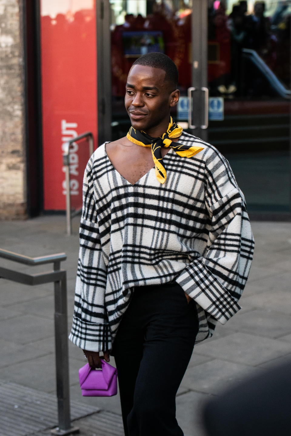 Ncuti Gatwa wears a JW Anderson top, scarf, bag and trousers during London Fashion Week February 2023