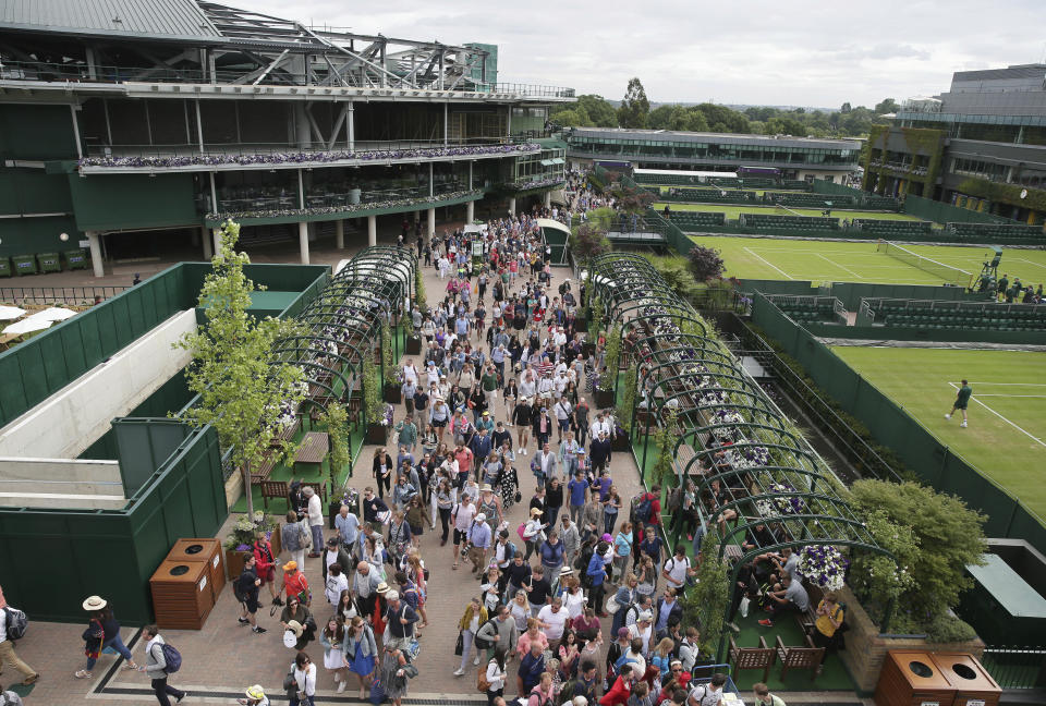 FILE - Spectators walk through the grounds before the start of the opening day at the Wimbledon Tennis Championships in London Monday, July 3, 2017. (AP Photo/Tim Ireland, File)