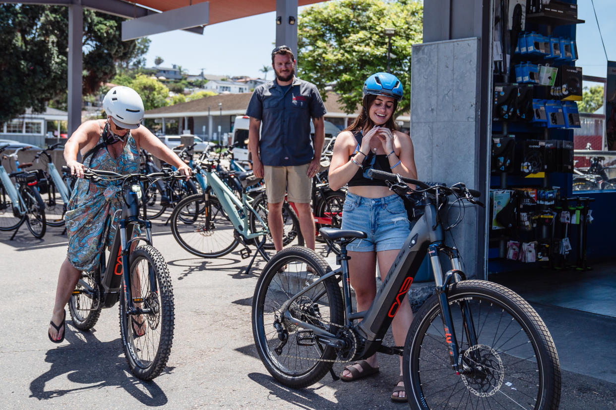 Una madre y su hija con bicicletas eléctricas rentadas en una tienda en Encinitas, California, el 18 de julio de 2023. (Ariana Drehsler/The New York Times)