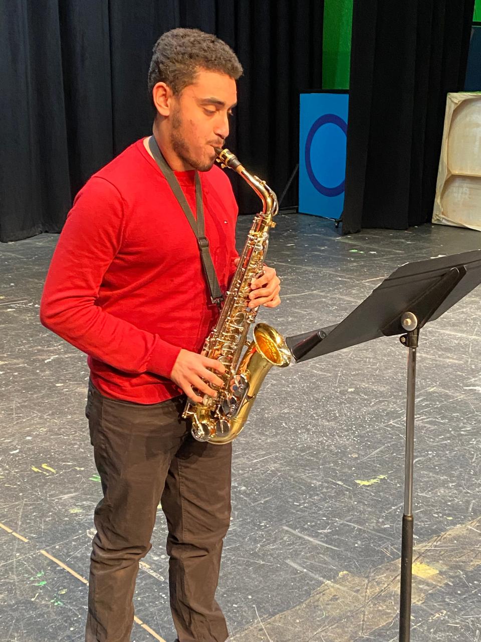 Taunton High School senior Caio Dos Santos-Amado practices the saxophone in the auditorium on Feb. 1, 2023.