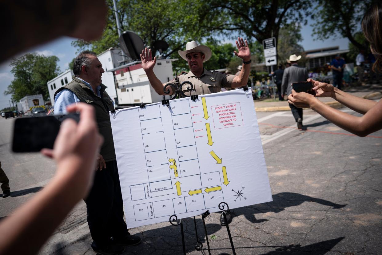 Members of the media take photos of a map of the school which was used a press conference held outside Robb Elementary School on Friday in Uvalde, Texas. 