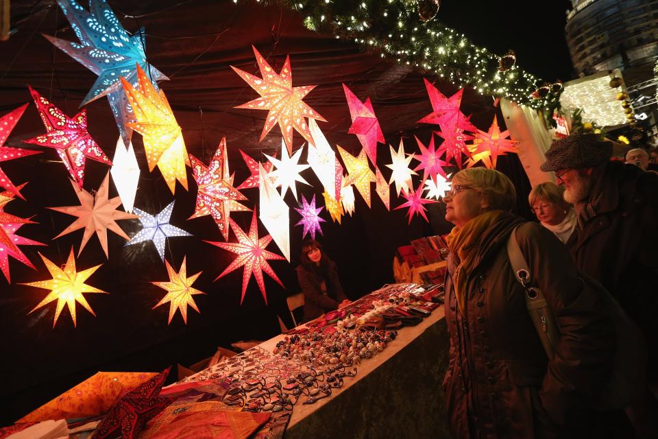 BERLIN, GERMANY - NOVEMBER 26: Visitors look at illuminated Christmas starts for sale at the annual Christmas market at Gendarmenmarkt on its opening day on November 26, 2012 in Berlin, Germany. Christmas markets, with their stalls selling mulled wine (Gluehwein), Christmas tree decorations and other delights, are an integral part of German Christmas tradition, and many of them opened across Germany today. (Photo by Sean Gallup/Getty Images)