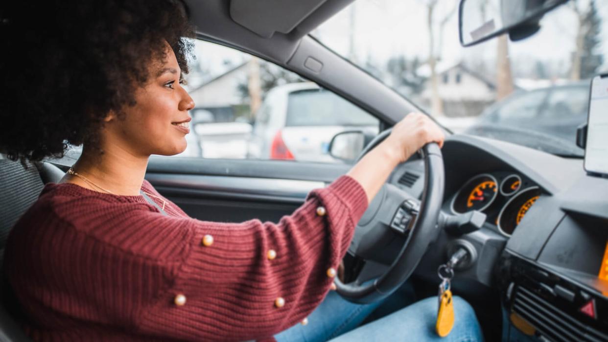 Young African American woman driving the car.