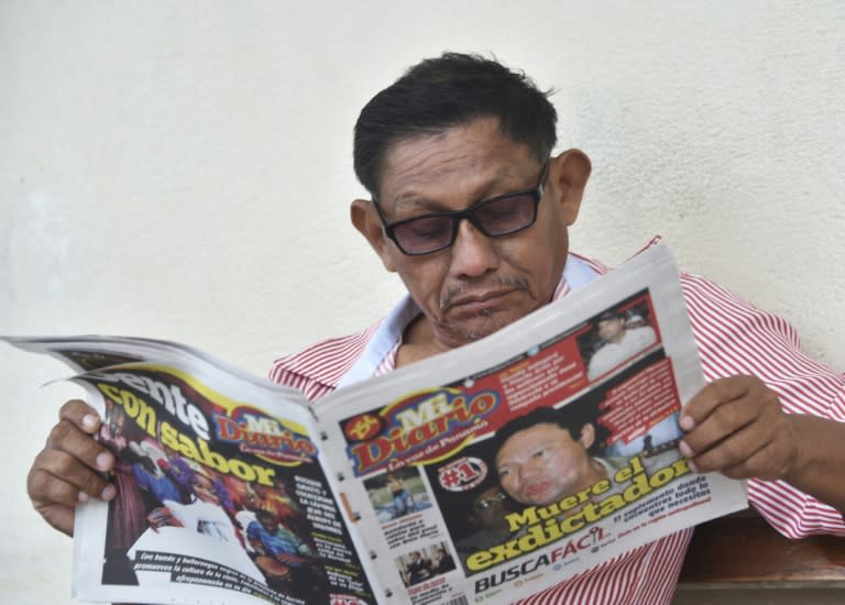 A man reads a newspaper announcing the death of Former Panamanian dictator Manuel Antonio Noriega on May 30, 2017, outside Santo Tomas Hospital in Panama City