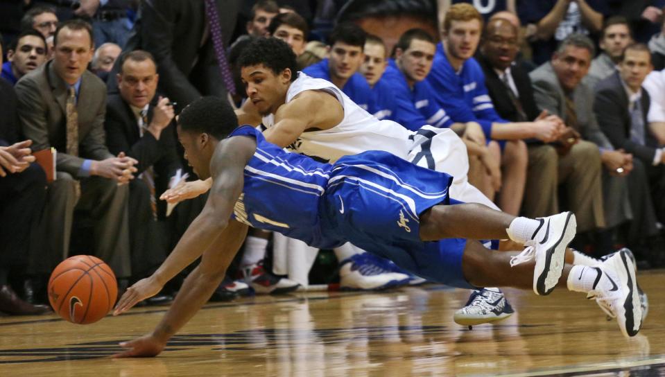 Creighton's Austin Chatman dives for a loose ball with Xavier's Dee Davis during the first half of an NCAA college basketball game in Cincinnati on Saturday March 1, 2014. (AP Photo/Tom Uhlman)