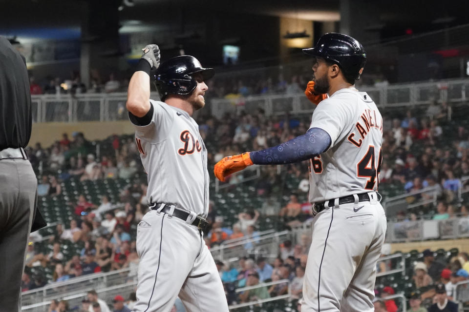 Detroit Tigers' Robbie Grossman, left, and Jeimer Candelario celebrate Grossman's two-run home run off Minnesota Twins pitcher Hansel Robles to tie the baseball game in the eighth inning, Monday, July 26, 2021, in Minneapolis. The Twins won 6-5 in 10 innings. (AP Photo/Jim Mone)