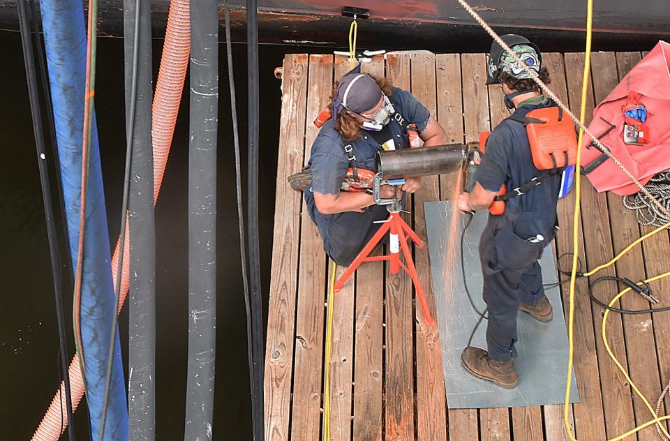 As seen from above, workers make repairs to Battleship Cove's Battleship Massachusetts Friday, Aug. 5, 2022.