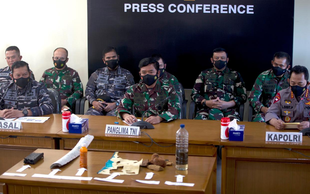 Indonesian Navy Chief Yudo Margono, front left, Indonesian Military chief Hadi Tjahjanto, center, and Indonesia police chief Listyo Sigit Prabowo, right, talk to media as they display debris found in the waters.