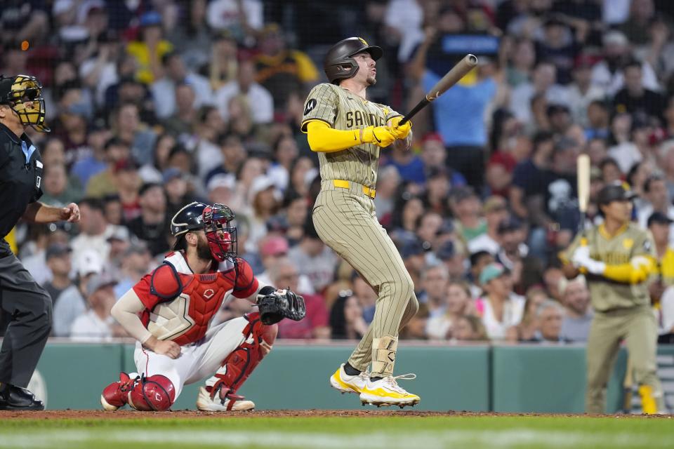 San Diego Padres' Jackson Merrill, front right, follows through on his three-run home run in front of Boston Red Sox catcher Connor Wong during the fifth inning of a baseball game, Friday, June 28. 2024, in Boston. (AP Photo/Michael Dwyer)