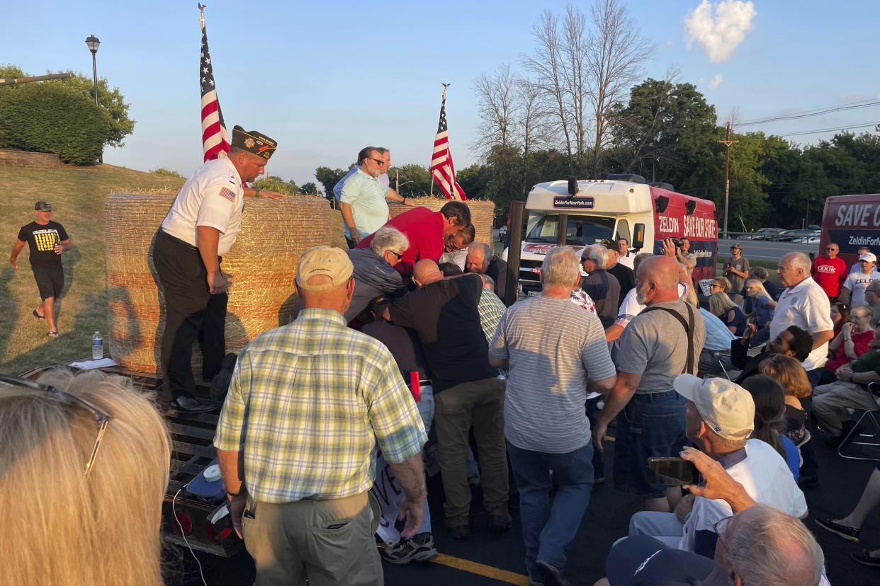 In this photo provided by Ian Winner, people subdue a person who assaulted U.S. Rep. Lee Zeldin, the Republican candidate for New York governor, at a campaign appearance Thursday, July 21, 2022, in Fairport, N.Y. Zeldin escaped serious injury. 