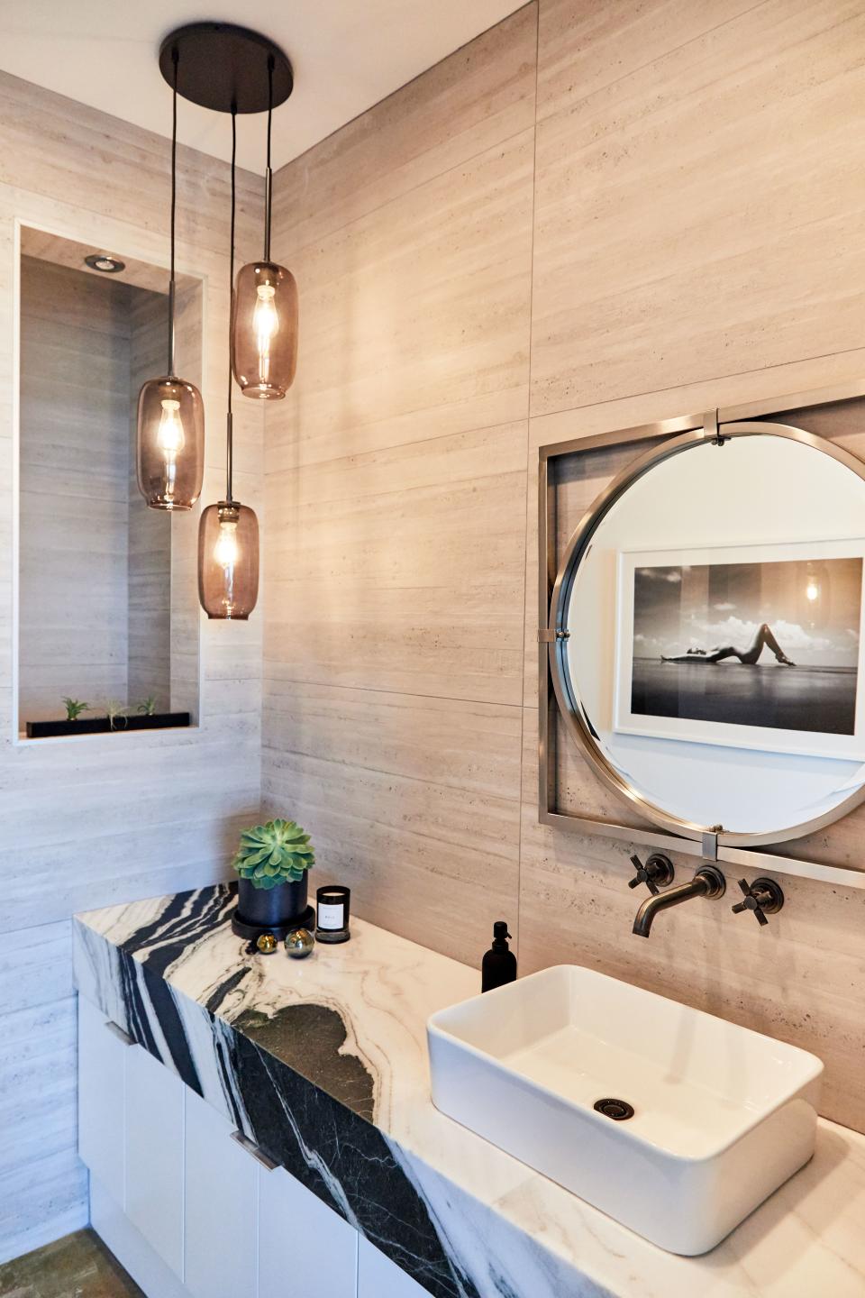 Huston chose black-and-white marble for the powder room, with cement tile for the walls and an exotic black-and-white photograph, also by Harry Mark; “I thought fit pretty good in there,” he says.