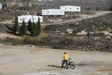 An Israeli boy holds his bicycle near homes in the Jewish settler outpost of Amona in the West Bank December 5, 2016. REUTERS/Baz Ratner