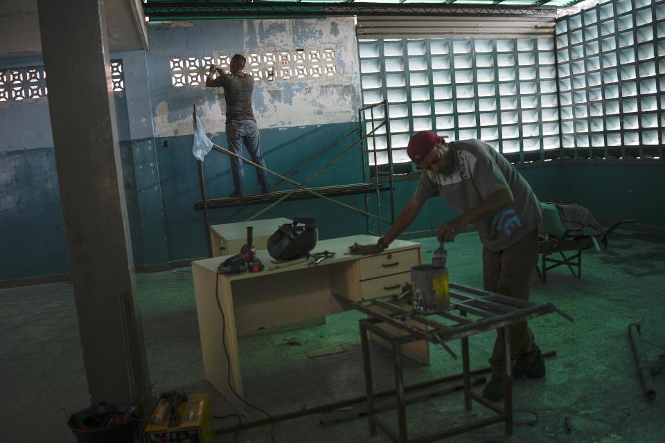 FILE - Workers rehab the lunchroom of a public school while students are out for summer vacation in Caracas, Venezuela, Wednesday, Aug. 10, 2022. A few days into their long break, teachers have been marching by the thousands around the country, threatening to strike when school resumes or possibly even to abandon their profession after the government paid them only a tiny fraction of their annual vacation bonus. (AP Photo/Matias Delacroix, File)