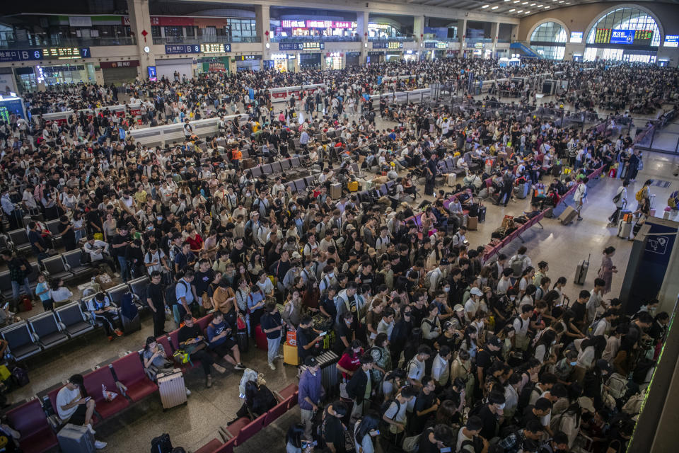 In this photo released by Xinhua News Agency, travelers prepare to catch their trains at the crowded Hankou Railway Station in Wuhan, central China's Hubei Province on Thursday, Sept. 28, 2023. Tens of millions of Chinese tourists are expected to travel within their country, splurging on hotels, tours, attractions and meals in a boost to the economy during the 8-day autumn holiday period that began Friday. (Wu Zhizun/Xinhua via AP)