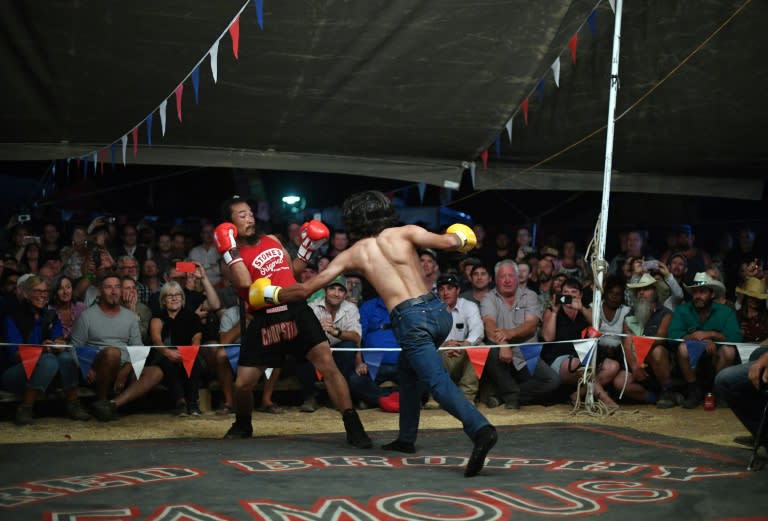 After sundown, many head to a boxing tent, where audience members can challenge the members of a travelling boxing troupe to a fight in front of cheering spectators