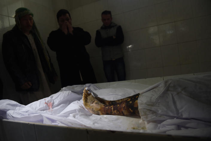 <p>Afghan relatives react as they stand near the body of Saeed Jawad Hossini, 29, who was killed in a suicide attack on a minibus carrying employees of Afghan TV channel TOLO in Kabul on January 21, 2016. Seven employees of popular Afghan TV channel TOLO were killed on January 21 when a Taliban car bomber rammed into their minibus in Kabul, just months after the militants declared the network a legitimate “military target”. (Photo: Shah Marai/ AFP/Getty Images) </p>
