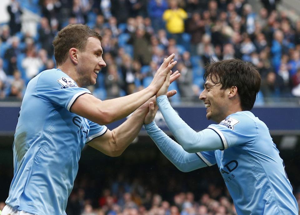 Manchester City's Edin Dzeko (L) celebrates with team mate David Silva after scoring a goal during their English Premier League soccer match against Southampton at the Etihad stadium in Manchester, northern England April 5, 2014. REUTERS/Darren Staples (BRITAIN - Tags: SPORT SOCCER) FOR EDITORIAL USE ONLY. NOT FOR SALE FOR MARKETING OR ADVERTISING CAMPAIGNS. NO USE WITH UNAUTHORIZED AUDIO, VIDEO, DATA, FIXTURE LISTS, CLUB/LEAGUE LOGOS OR "LIVE" SERVICES. ONLINE IN-MATCH USE LIMITED TO 45 IMAGES, NO VIDEO EMULATION. NO USE IN BETTING, GAMES OR SINGLE CLUB/LEAGUE/PLAYER PUBLICATIONS