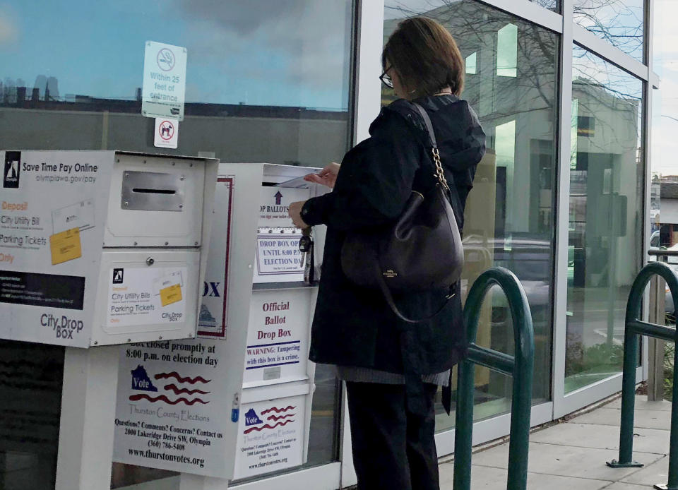 Sandy St. Dennis drops her ballot at a drop box outside of Olympia City Hall in Olympia, Wash., Monday, Nov. 5, 2018. St. Dennis said she was concerned about policies related to climate change, immigration and women's rights and said she hoped Democrats regained control of Congress. (AP Photo/Rachel La Corte)