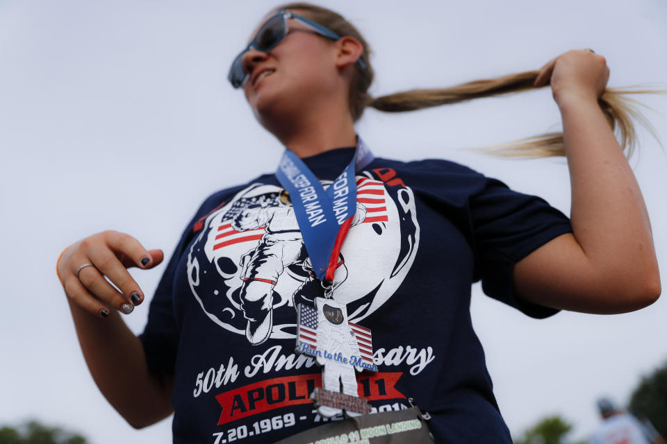 A runner receives her medal after participating in the "Run for the Moon" race outside the Armstrong Air and Space Museum as special events are underway for visitors commemorating the 50th anniversary of the first moon landing, Saturday, July 20, 2019, in Wapakoneta, Ohio. (AP Photo/John Minchillo)